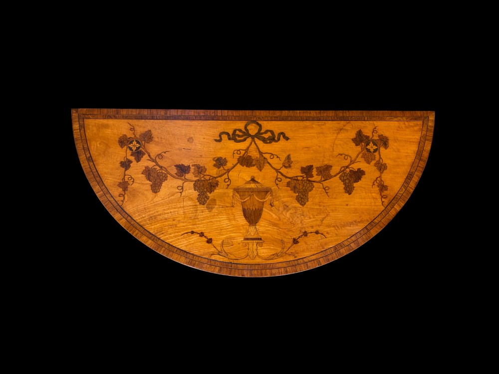 A pair of George III period semi-circular satinwood side tables featuring inlaid marquetry tops and square tapered legs. View III
