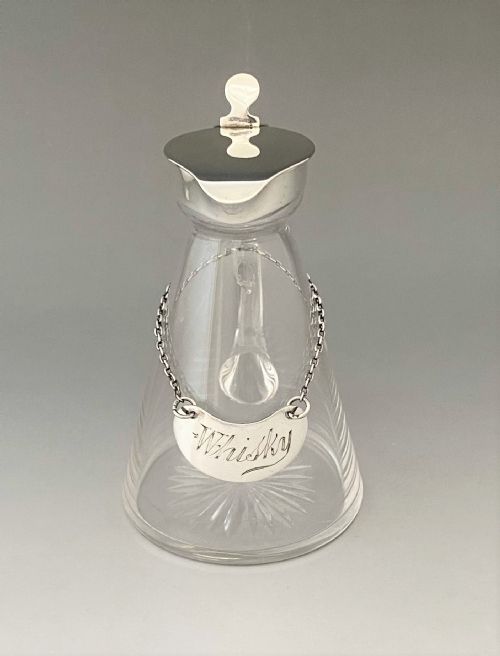 fig 1. An Asprey silver mounted Whisky tot with silver label