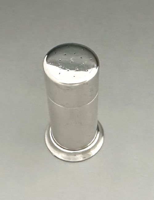 fig 1. A polished cylindrical sterling silver stamp moistener shown next to its original fabric storage pouch.