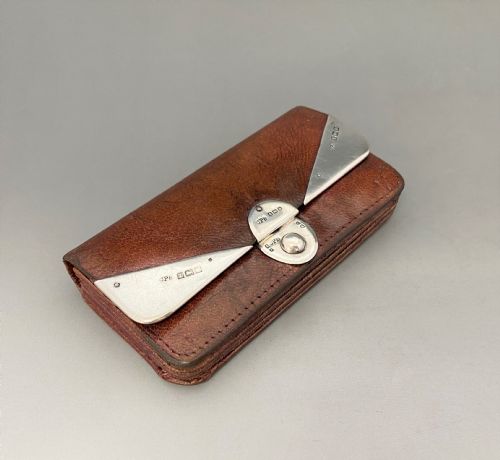 fig 1. An Edwardian brown leather purse featuring hallmarked sterling silver corner mounts and a central silver clasp fastener.