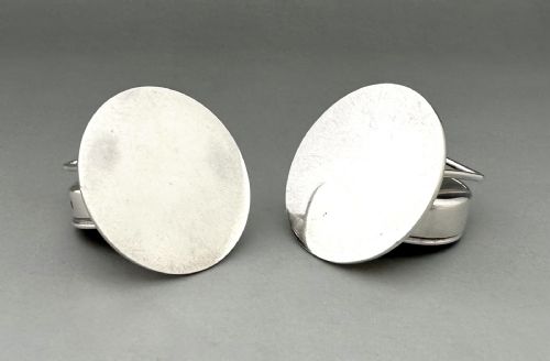fig 1. A pair of circular silver menu holders featuring deep blue enamelled centres set on flat round bases.