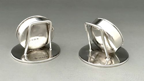 fig 2. A pair of circular silver menu holders featuring deep blue enamelled centres set on flat round bases.