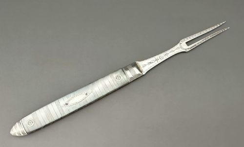 fig 1. A late eighteenth-century silver folding fruit fork featuring engraved two-pronged tines and a decorated mother-of-pearl handle on a neutral background.