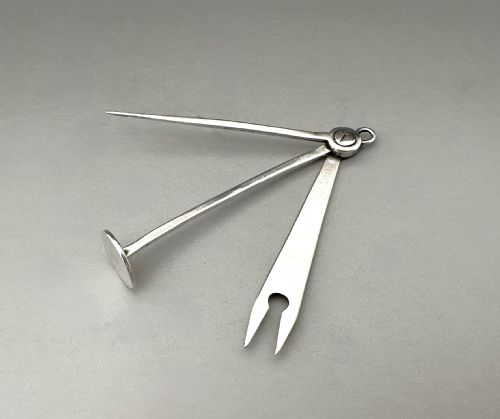 fig 1. An antique Victorian sterling silver folding pipe tool featuring three implements attached to a central ring pivot with visible hallmarks.