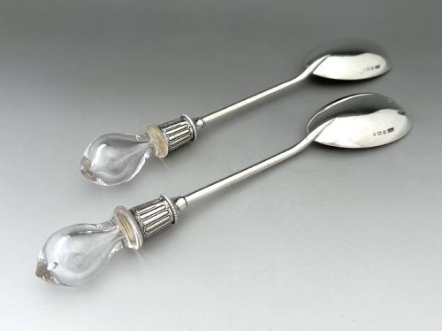 fig 1. A pair of Edwardian silver salad servers featuring a rounded spoon and a three-pronged fork with decorative fluted ferrules and clear glass drop handles.