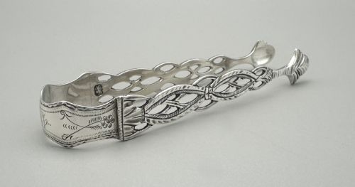 fig 1. A pair of 18th-century cast sterling silver sugar tongs featuring openwork pierced lattice arms and shell-shaped grips.