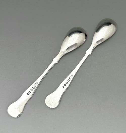 fig 1. A pair of polished Scottish sterling silver mustard spoons featuring detailed shell and scroll terminal decorations.