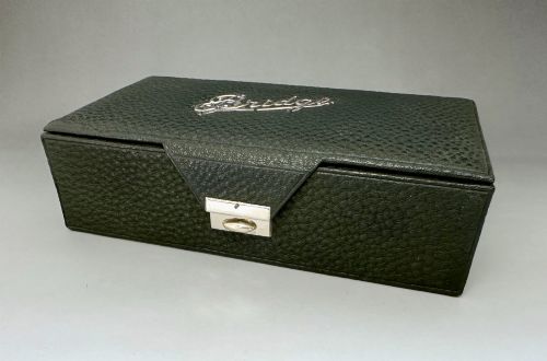 fig 1. A dark green pebbled leather rectangular bridge box featuring applied silver script spelling Bridge on the top cover and a silver clasp closure.