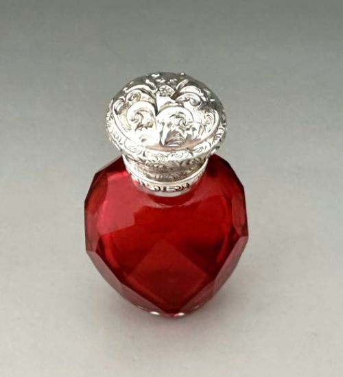 fig 1. A Victorian faceted ruby red glass scent bottle featuring an intricately embossed silver cap.