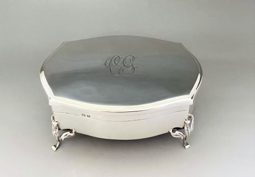 fig 1. A silver jewellery trinket box with a hinged monogrammed lid supported on four decorative cabriole legs.