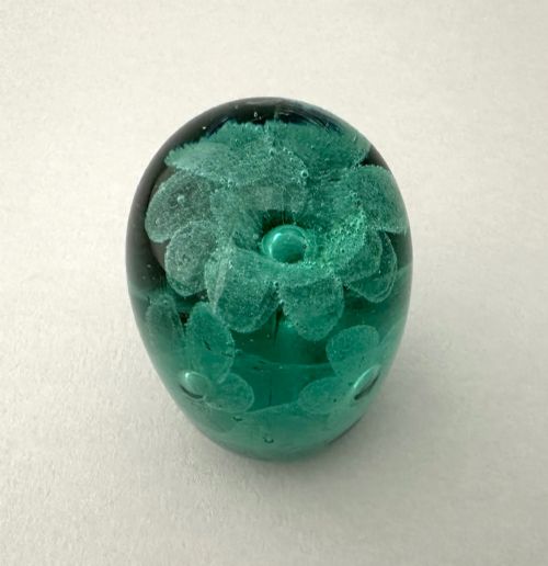 fig 1. A heavy oval green glass paperweight displaying an internal controlled bubble floral motif.