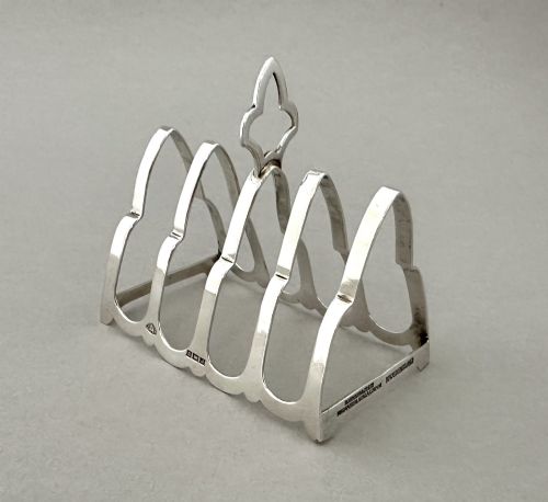 fig 2. A hallmarked silver four-slice toast rack featuring shaped Gothic arch dividers and a central pierced top handle.