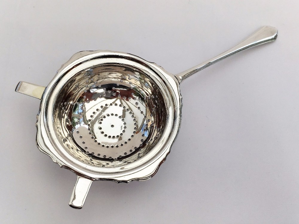 A gorgeous George V silver tea strainer.