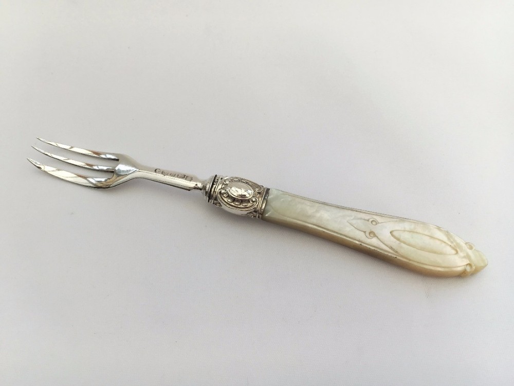 An early Victorian silver and mother-of-pearl pickle fork.