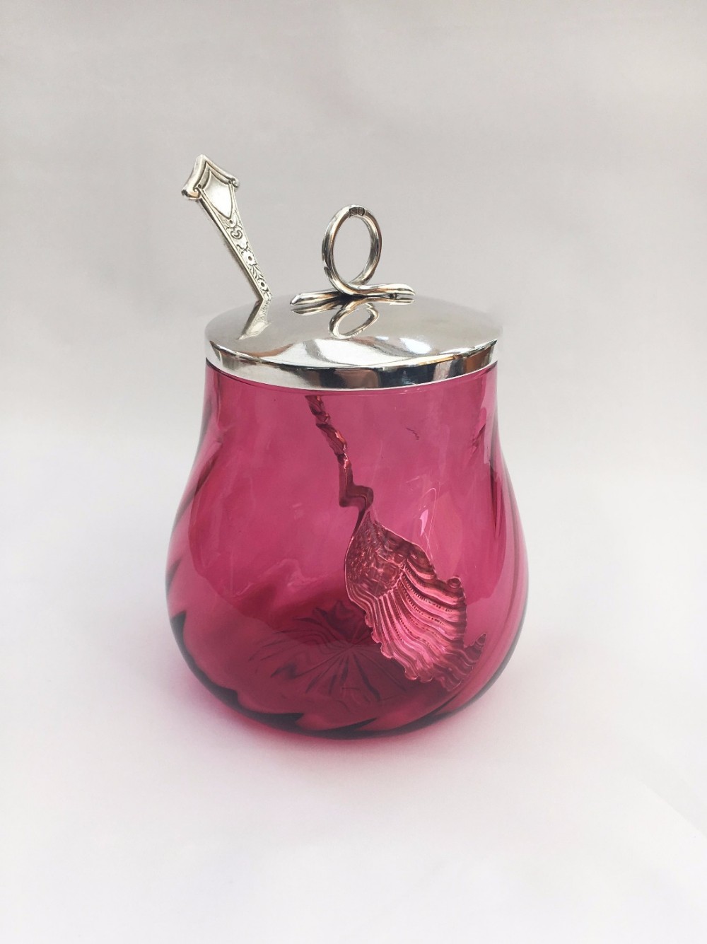 A gorgeous Victorian silver lidded cranberry preserve jar.
