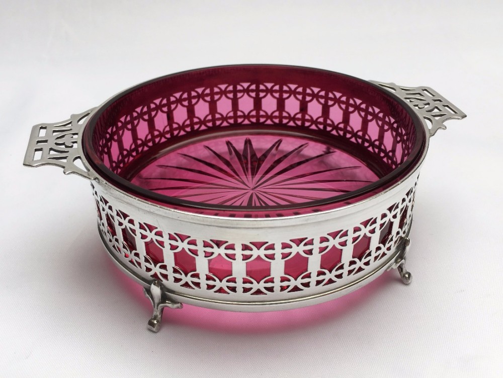A gorgeous pierced silver dish with cranberry glass liner.
