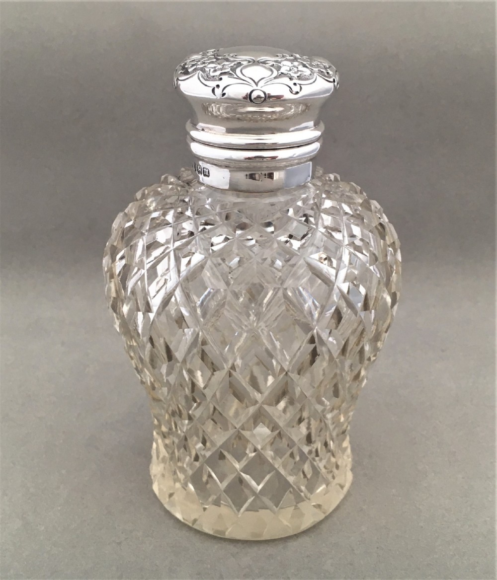 A gorgeous Edwardian silver mounted cologne bottle