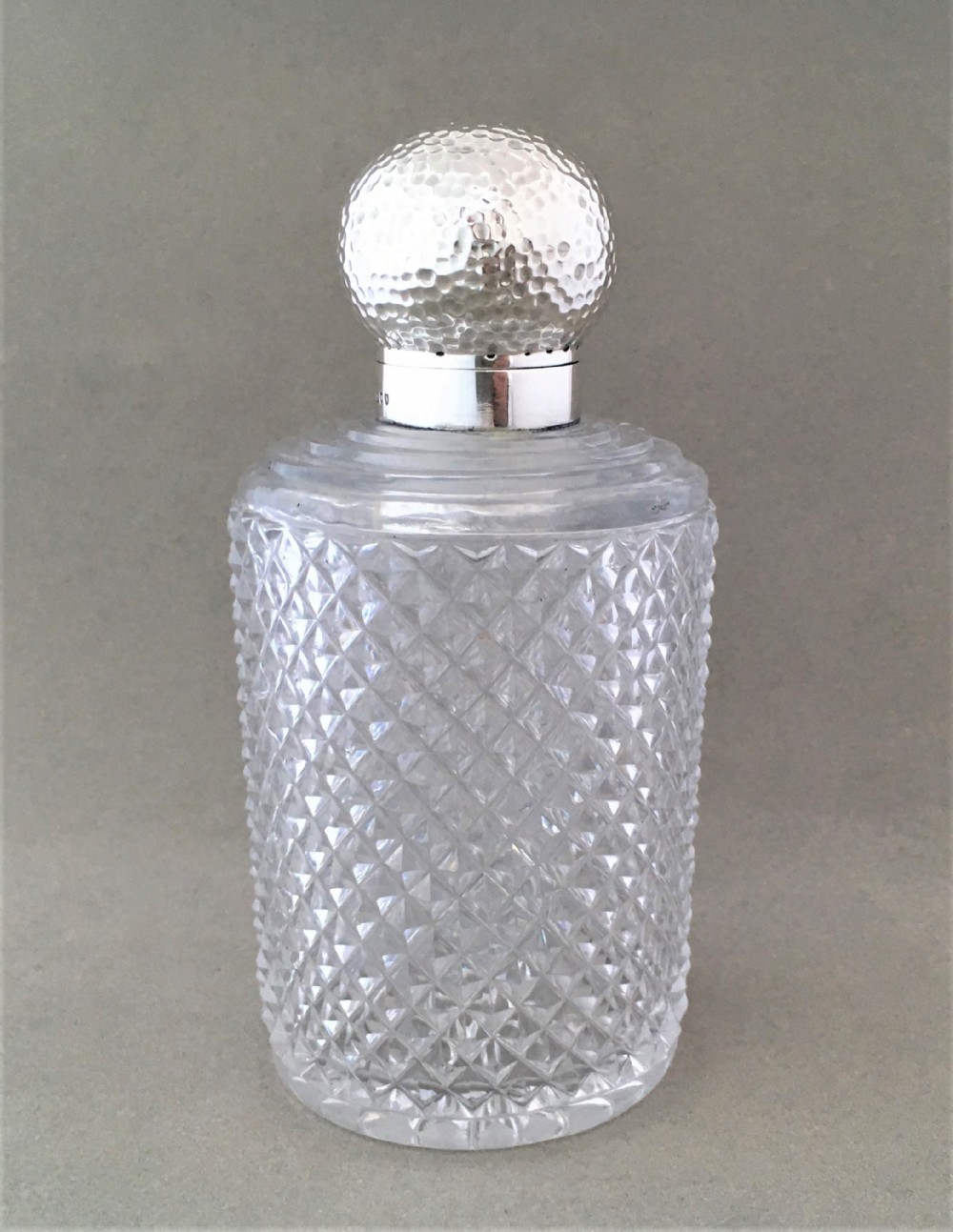 An arts & crafts inspired silver mounted cologne bottle