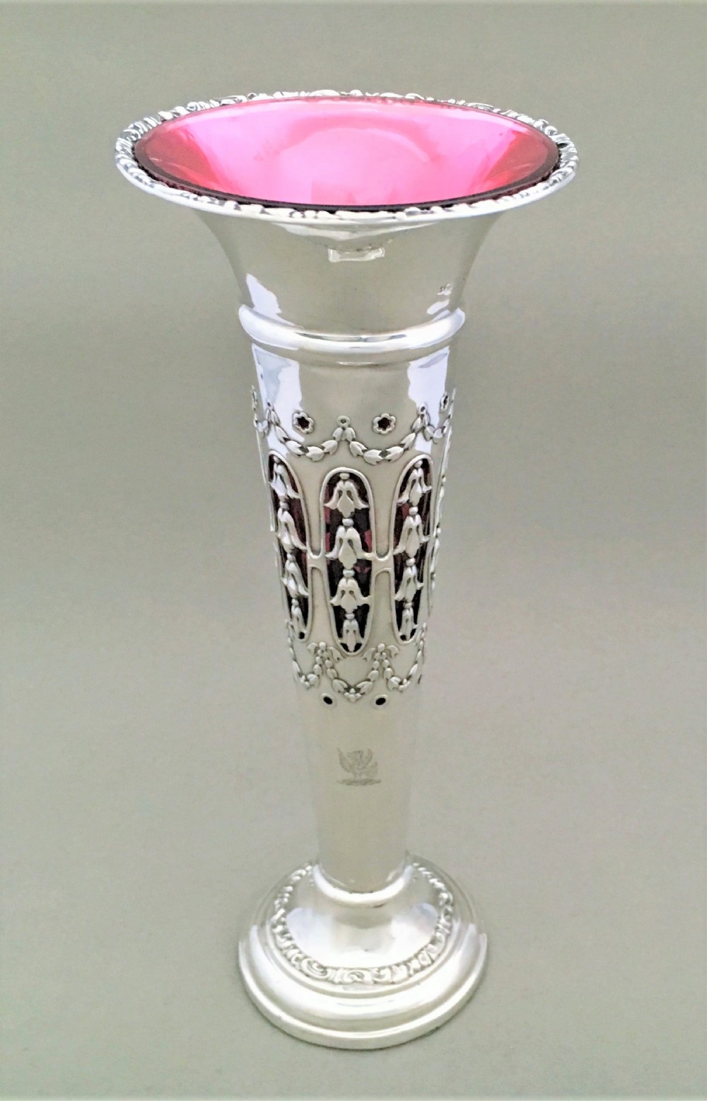 A stunning silver and cranberry pierced trumpet vase