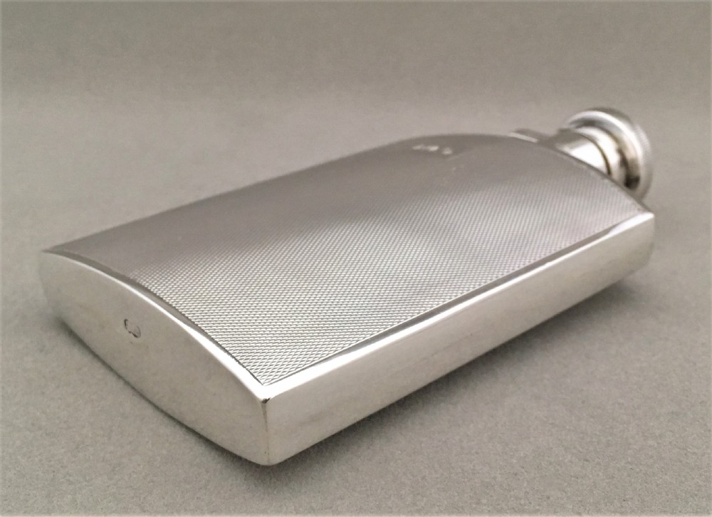 A silver hip flask with engine turned panels View IV