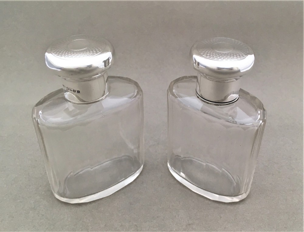 A charming pair of silver mounted cologne bottles