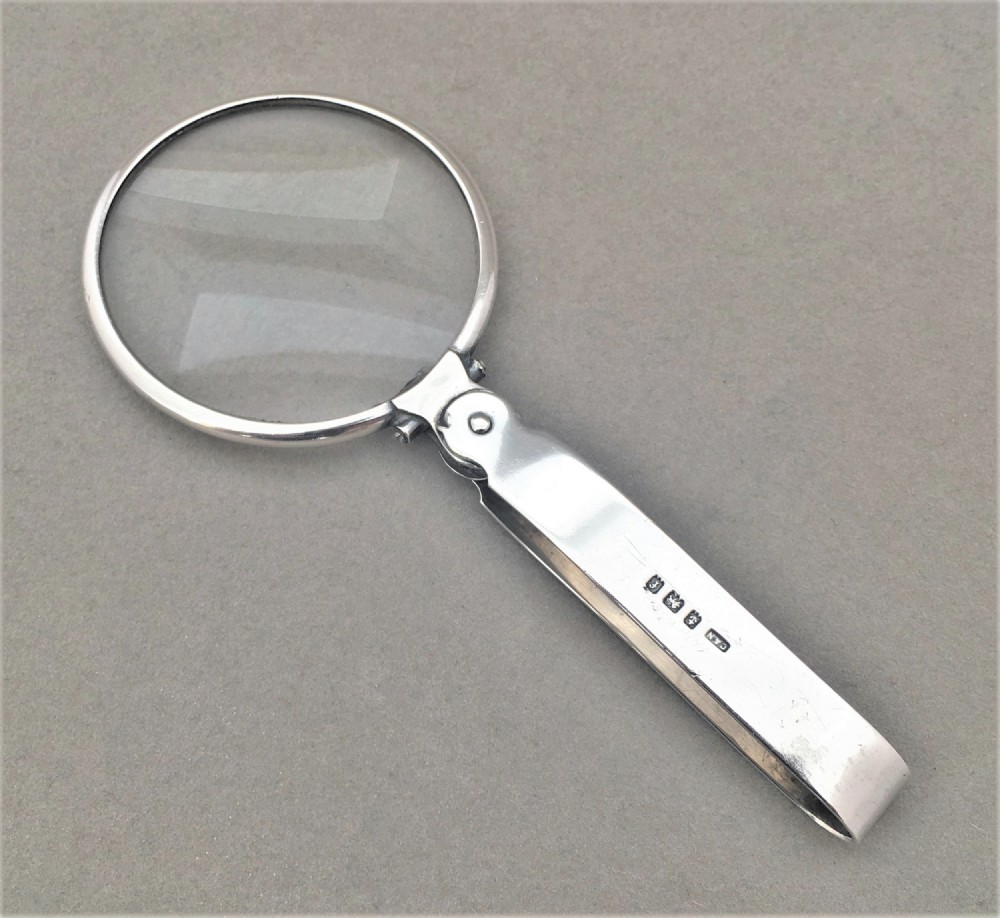 An unusual silver folding magnifying glass