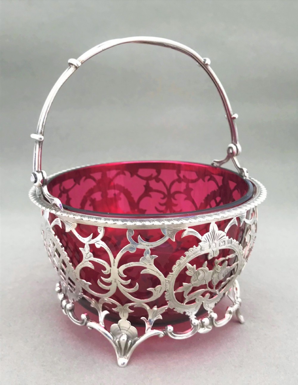 A stunning pierced silver & cranberry glass basket