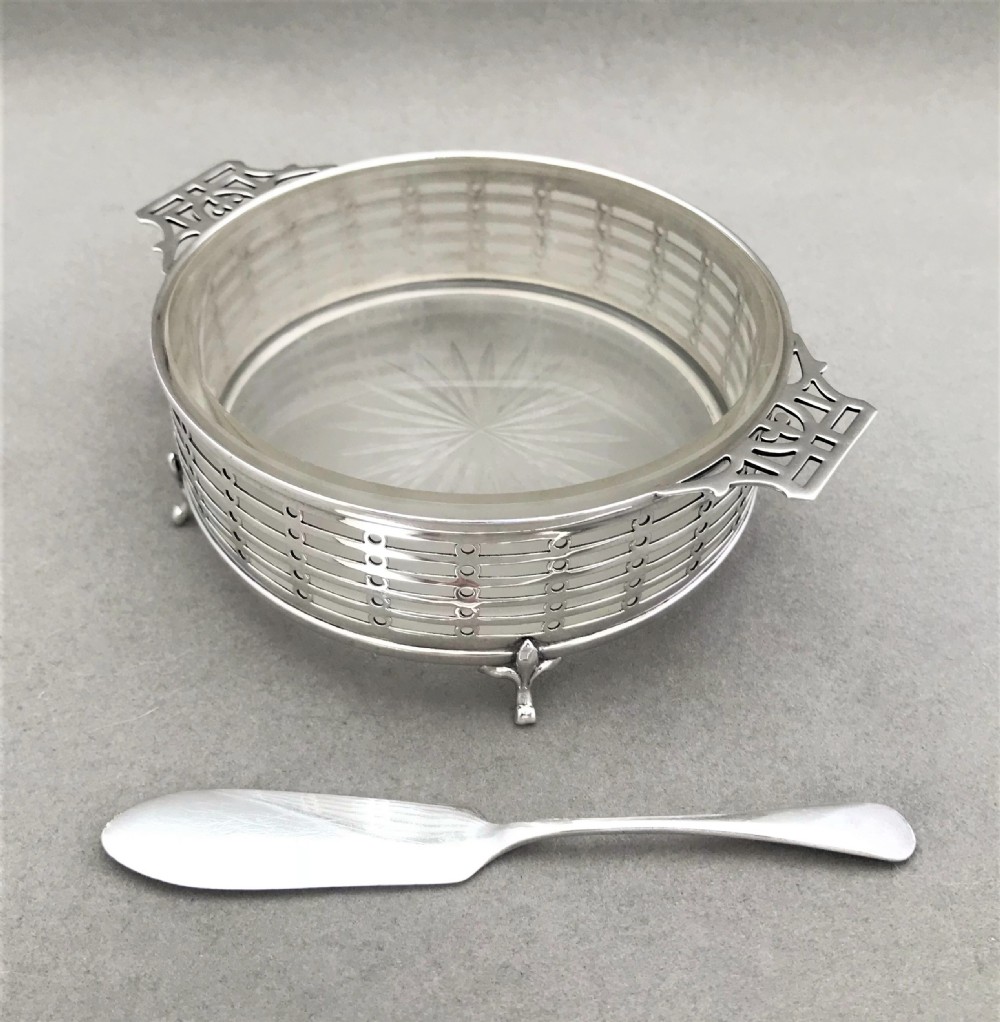 An attractive pierced silver butter dish with frosted glass liner