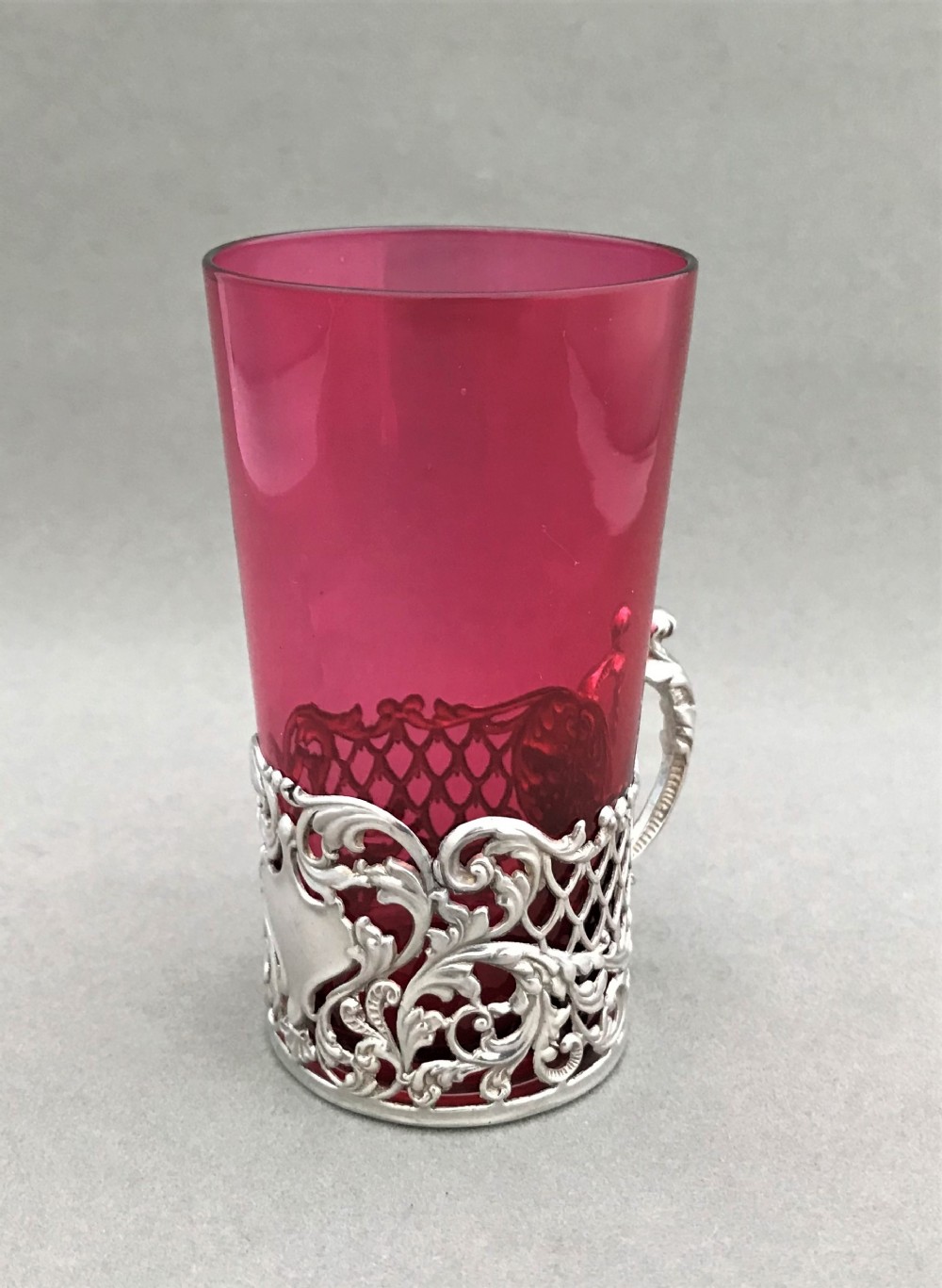 A lovely silver beaker holder with cranberry beaker