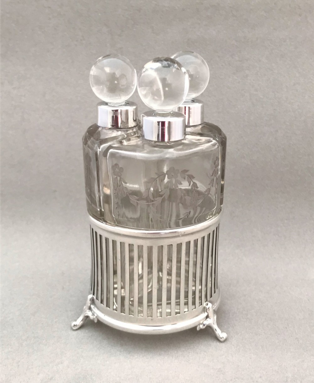 A gorgeous Edwardian silver mounted trio of scent bottles