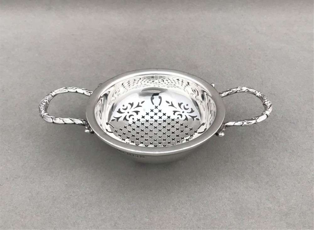 An attractive silver tea strainer