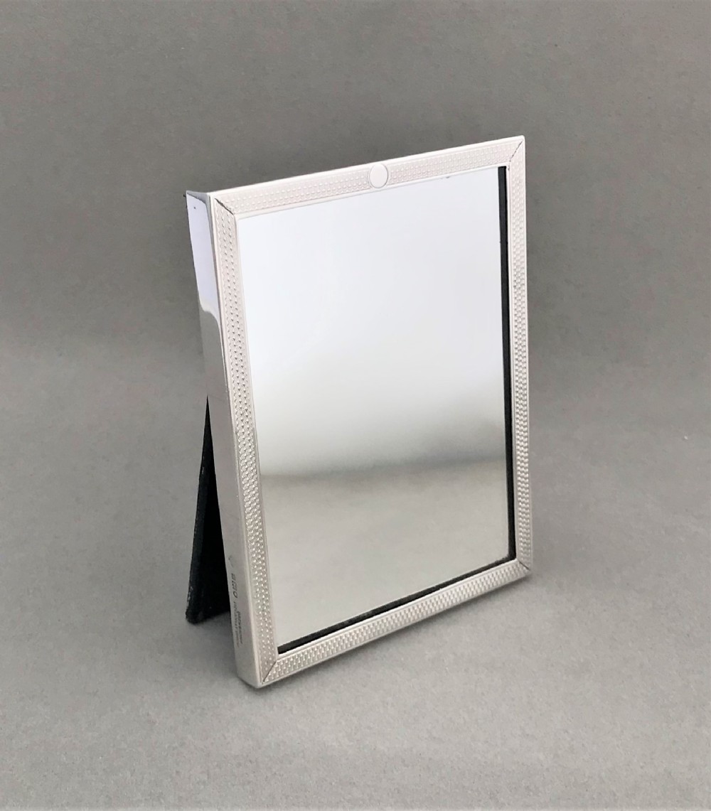 An unusual engine turned silver travelling mirror