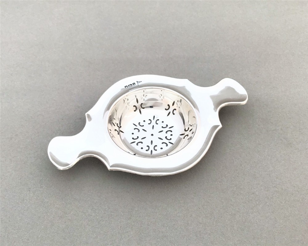 A gorgeous twin handled silver tea strainer