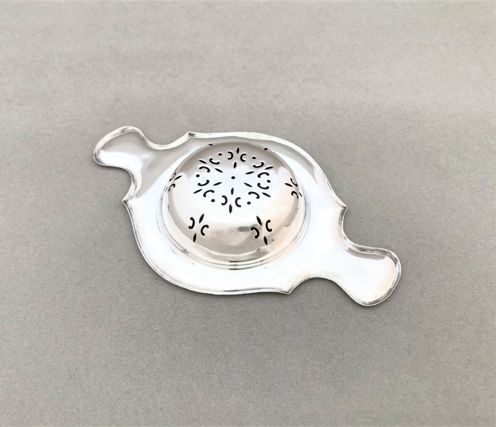 A gorgeous twin handled silver tea strainer View III