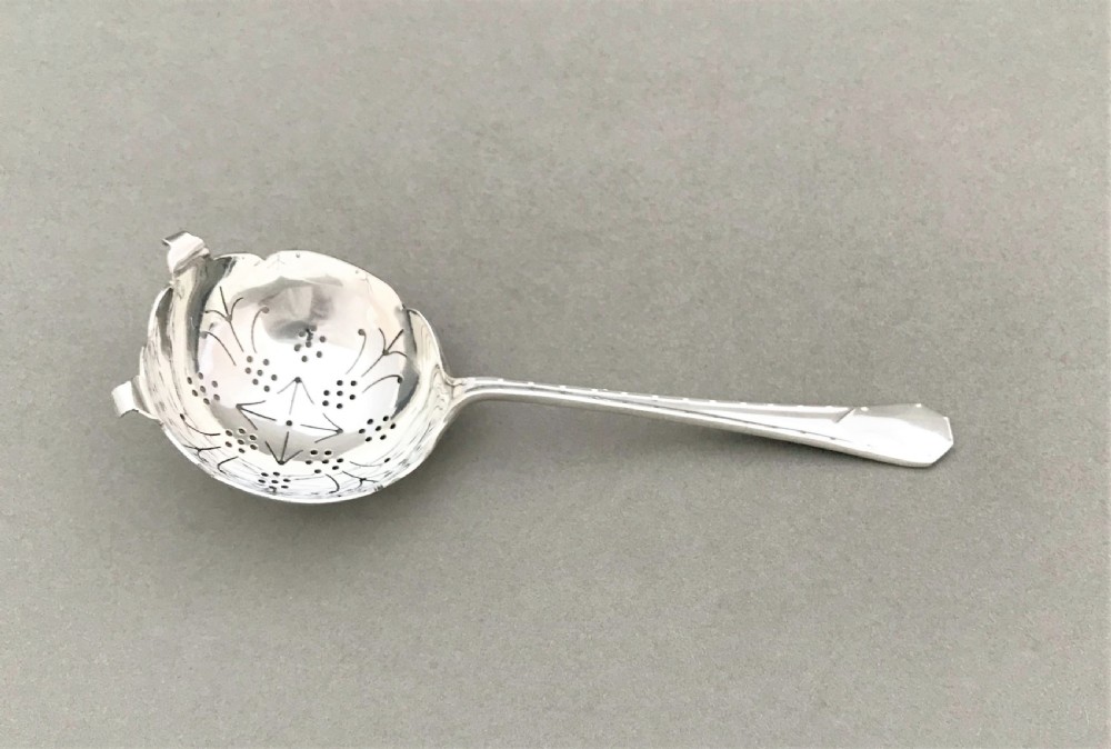 An Art Deco period silver tea strainer