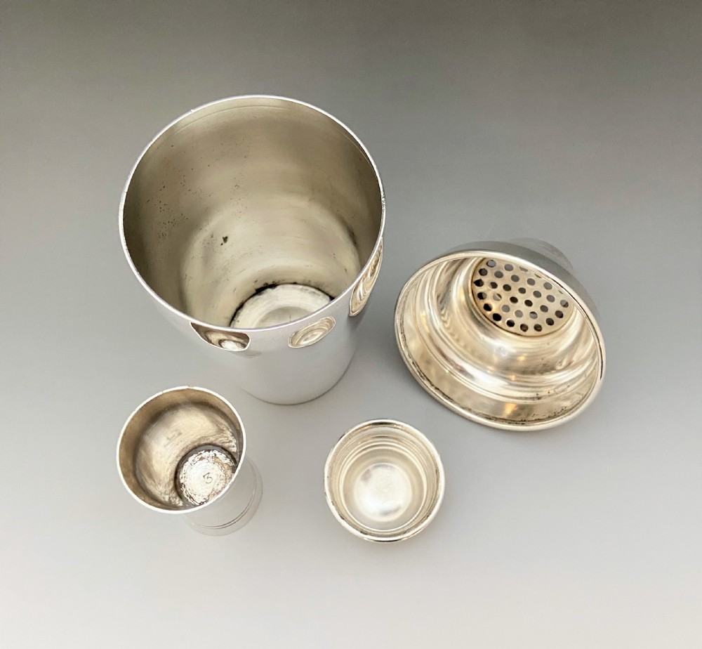 An Art Deco silver plated cocktail shaker & measure View VI