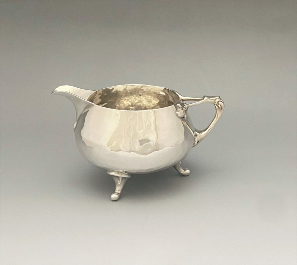 A fabulous Arts & Crafts small silver cream jug