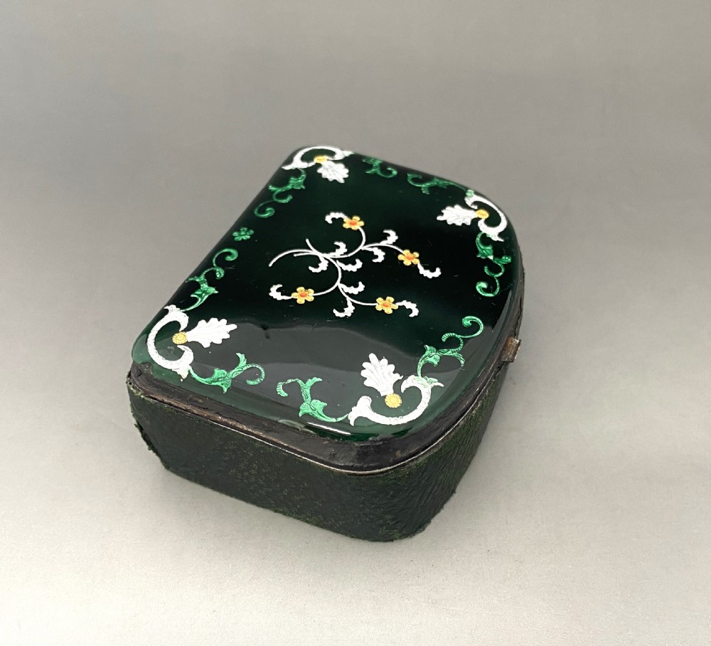 An antique dark green Georgian trinket box featuring a glass lid decorated with white, yellow, and green painted scrollwork motifs. View VI
