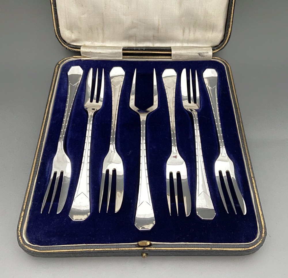 An excellent boxed set of six silver cake forks & serving fork
