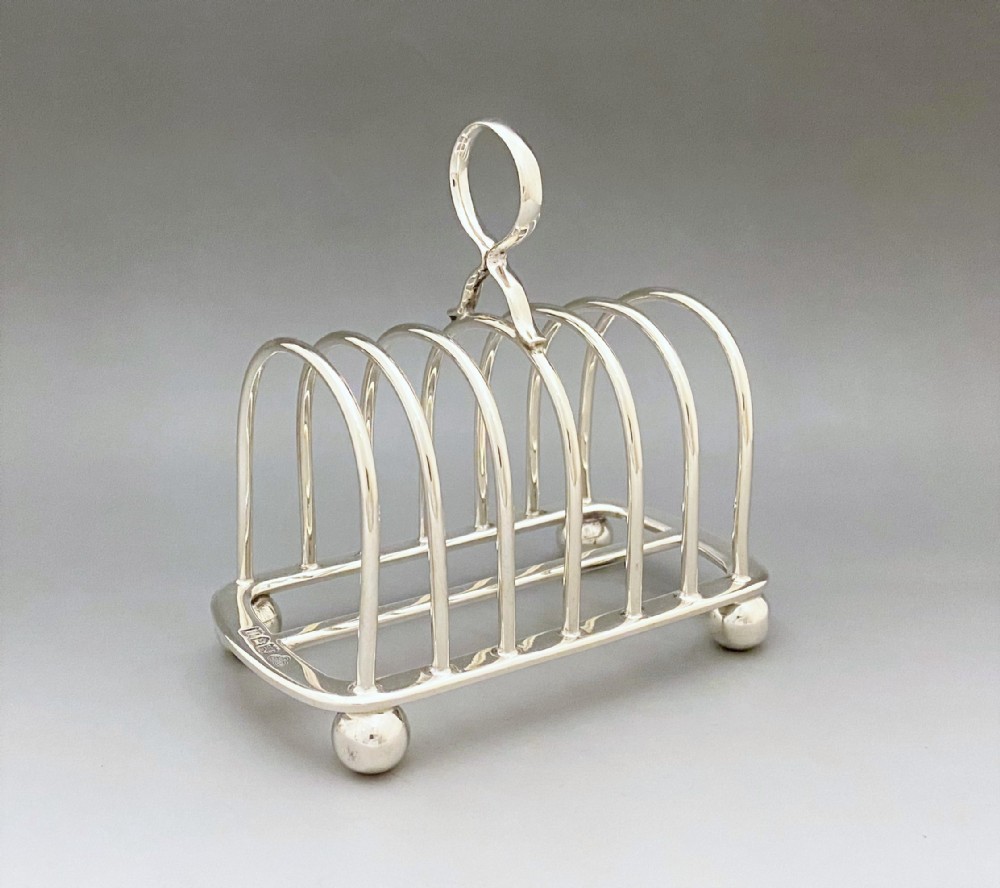 An Edwardian Goldsmiths & Silversmiths six slice silver toast rack