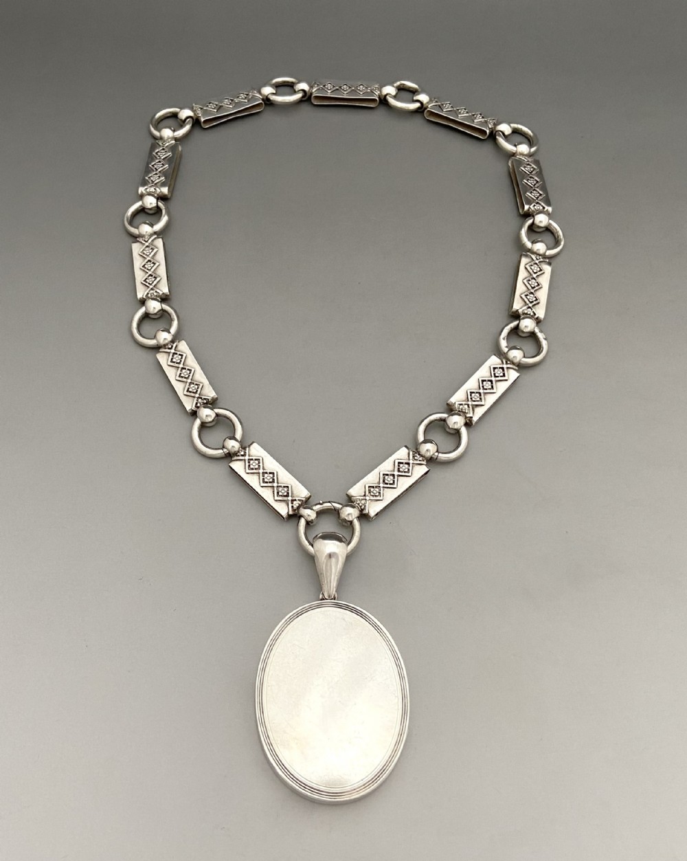 An unusual late Victorian silver neck chain & locket