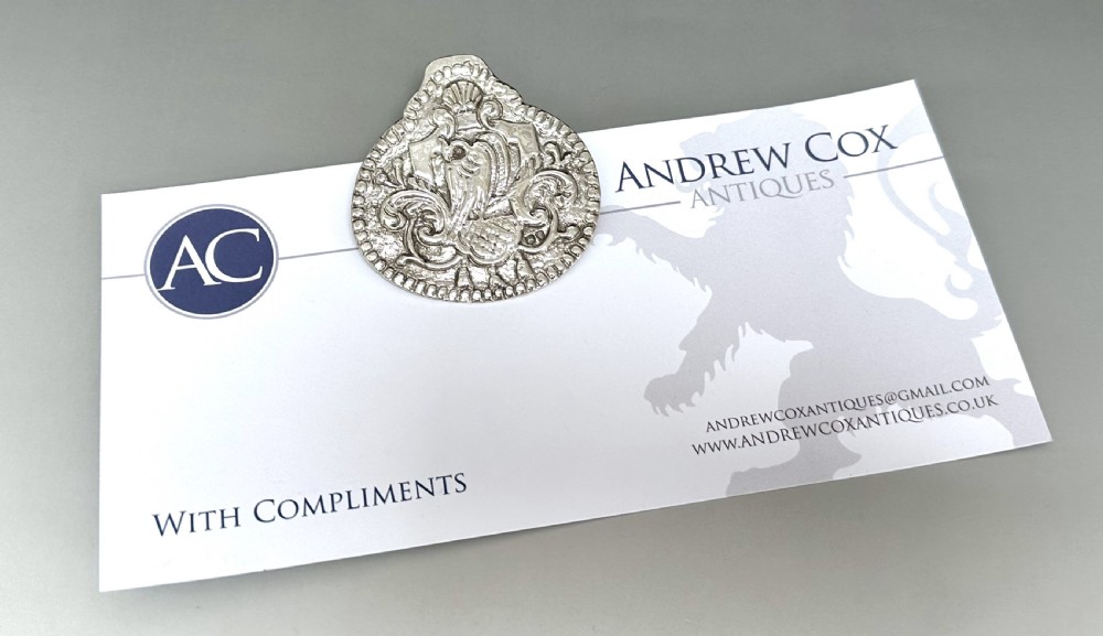 An antique Victorian silver desk clip featuring elaborate repousse relief decoration with a central bird motif and a beaded rim. View VII