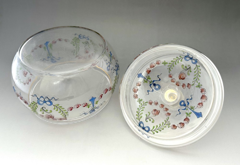 A clear glass lidded biscuit jar decorated with hand-painted enamelled pink roses, green foliage, and blue ribbons with a gilded rim band. View VI