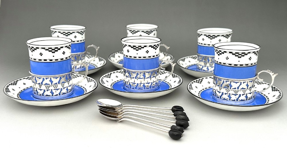 A set of six Art Deco blue porcelain coffee cans featuring pierced sterling silver mounts, matching saucers, and silver spoons with black coffee bean finials. View III