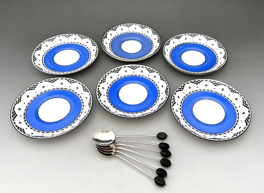 A set of six Art Deco blue porcelain coffee cans featuring pierced sterling silver mounts, matching saucers, and silver spoons with black coffee bean finials. View IV