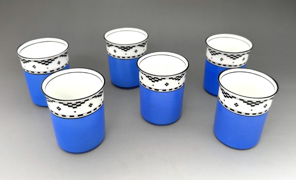 A set of six Art Deco blue porcelain coffee cans featuring pierced sterling silver mounts, matching saucers, and silver spoons with black coffee bean finials. View VII