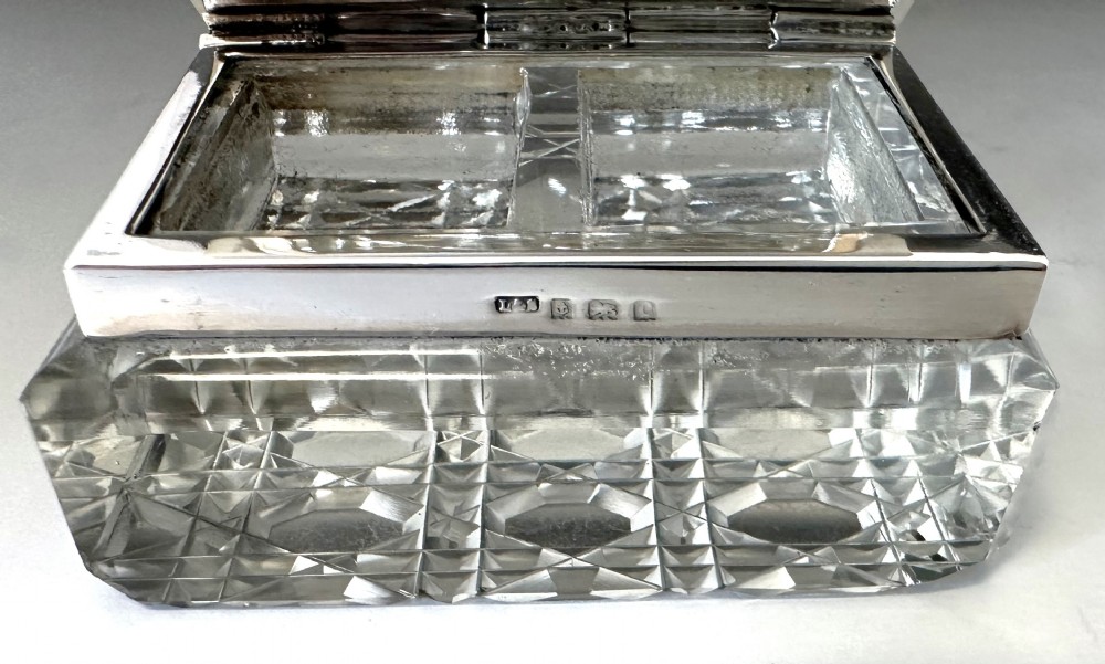 An Edwardian rectangular cut glass stamp box topped with a smooth sterling silver lid showing hallmarks along the rim. View VIII