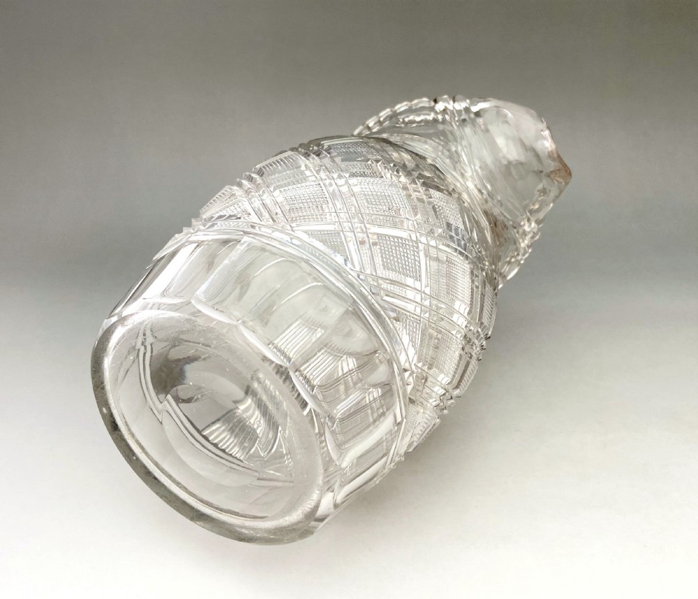 A clear Regency cut lead glass jug featuring diamond-pattern relief carving, a scalloped rim, and a thick curved handle. View VII