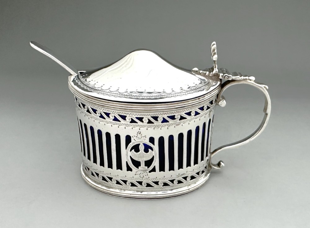 Victorian pierced sterling silver mustard pot with a domed hinged lid, scroll handle, and cobalt blue glass liner. View II
