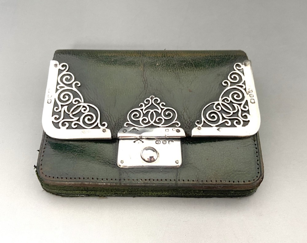 A dark green leather purse featuring intricate silver Art Nouveau corner mounts and a central silver clasp. View II